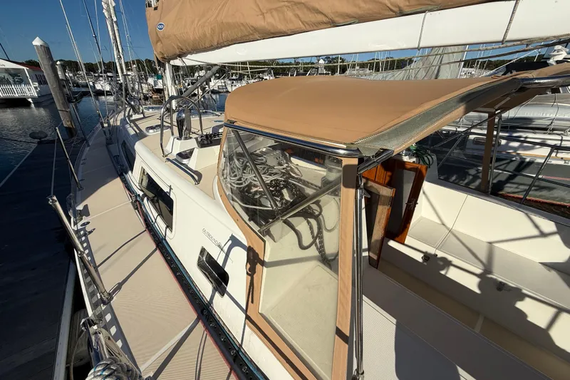 Pratique Yacht Photos Pics Sailboat docked at marina, Outbound 46 model, 2012, with tan canopy and clean deck.
