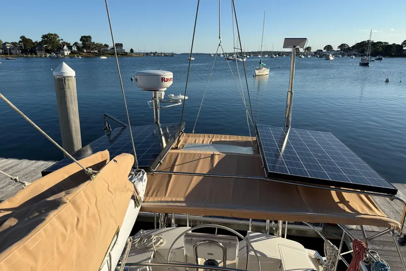 Pratique Yacht Photos Pics Sailboat docked with solar panels, Outbound 46 model, 2012, in a serene marina setting.