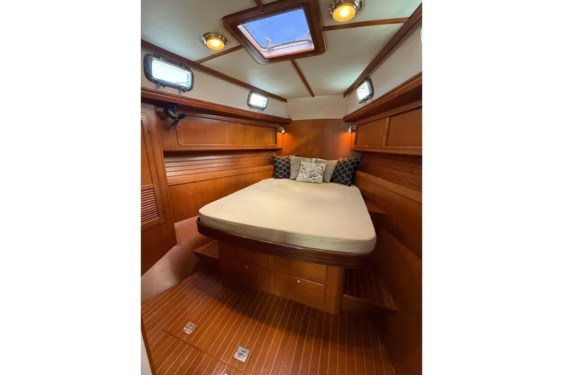 Pratique Yacht Photos Pics Luxurious cabin interior of 2012 Outbound 46 yacht with wooden finish and cozy bedding.