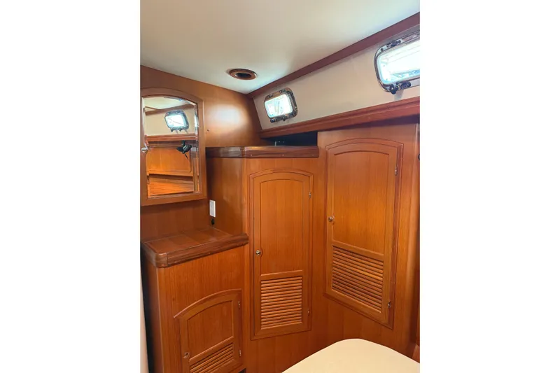 Pratique Yacht Photos Pics Wooden interior of 2012 Outbound 46 yacht with cabinets and portholes.