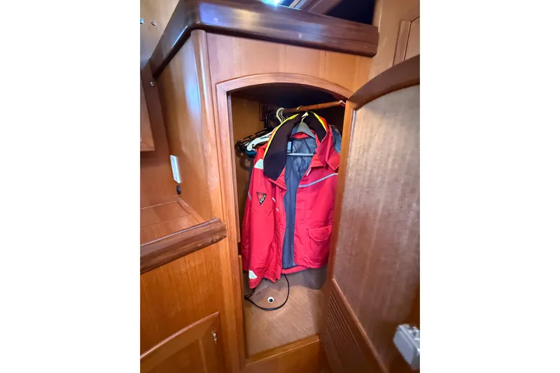 Pratique Yacht Photos Pics Wooden closet with red jacket inside, aboard a 2012 Outbound 46 yacht.