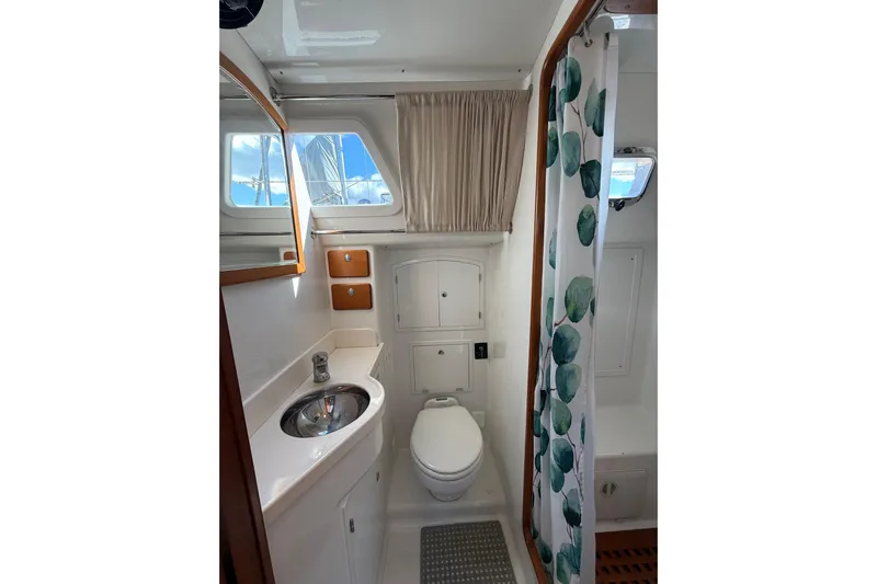 Pratique Yacht Photos Pics Compact bathroom in 2012 Outbound 46 yacht with sink, toilet, and shower curtain.