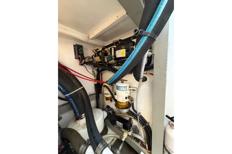 Pratique Yacht Photos Pics Engine compartment of a 2012 Outbound 46 yacht, featuring hoses and electrical components.