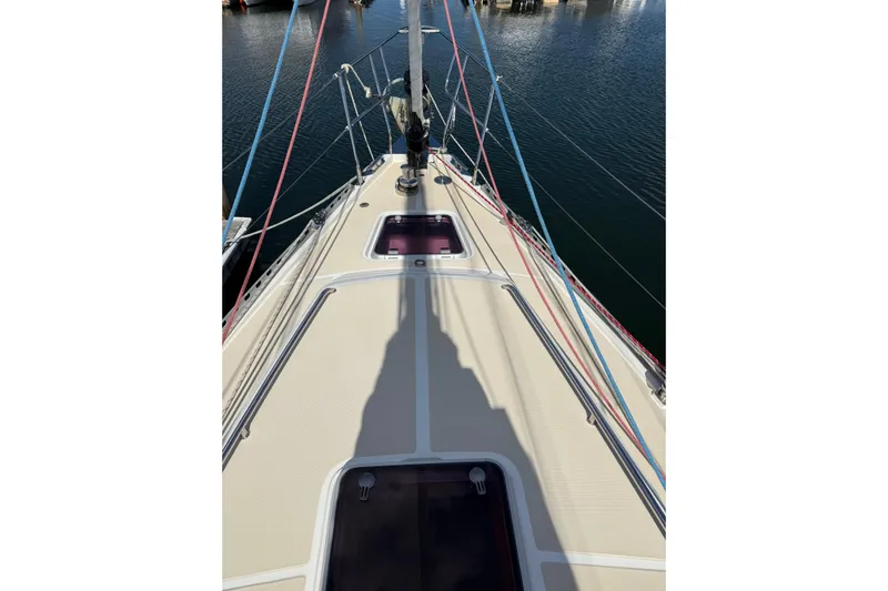 Pratique Yacht Photos Pics Deck view of 2012 Outbound 46 sailboat with colorful rigging in a marina.