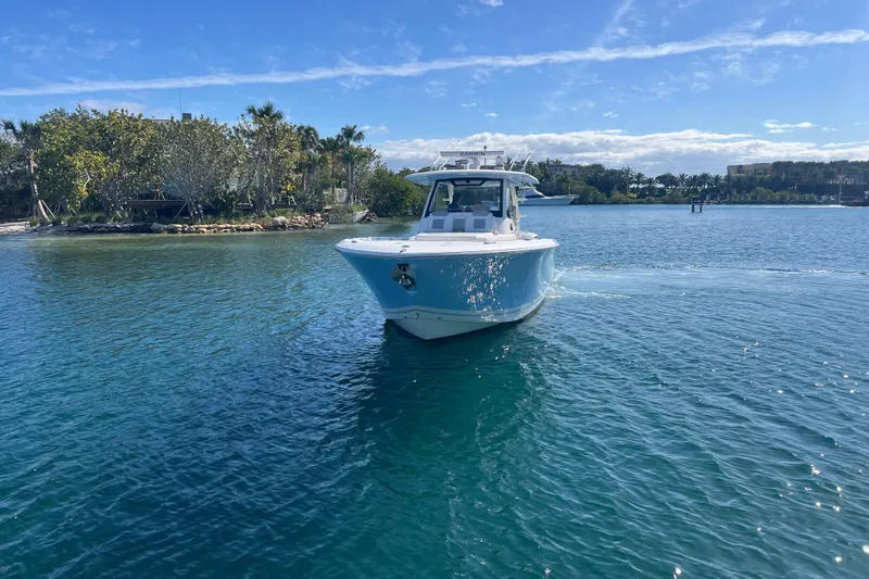  Yacht Photos Pics 2019 Pursuit S 368 Sport boat cruising on clear blue water.