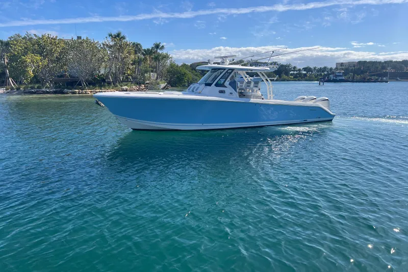  Yacht Photos Pics 2019 Pursuit S 368 Sport boat cruising on clear blue water.