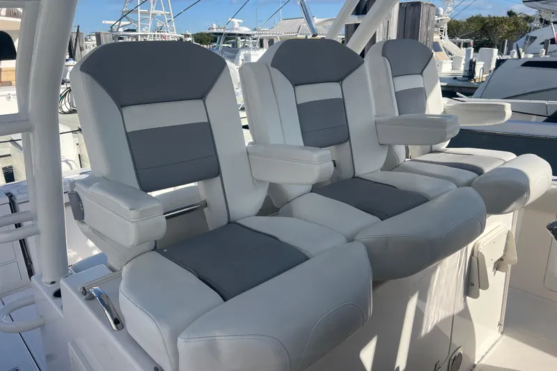  Yacht Photos Pics 2019 Pursuit S 368 Sport boat seats, featuring gray and white cushioned design at a marina.
