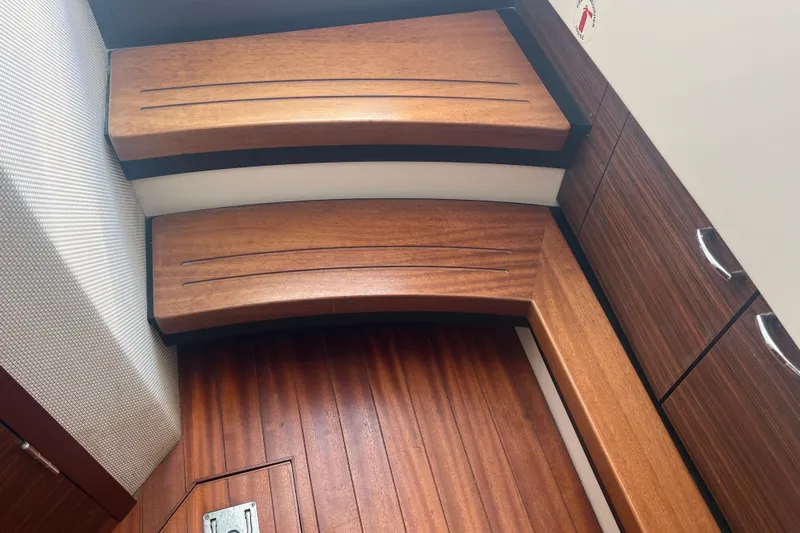  Yacht Photos Pics 2019 Pursuit S 368 Sport interior with wooden steps and cabinetry.