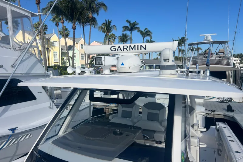  Yacht Photos Pics 2019 Pursuit S 368 Sport boat with Garmin equipment, docked near palm trees.