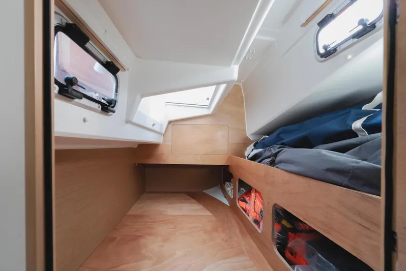  Yacht Photos Pics Interior cabin of 2026 Jeanneau Sun Odyssey 350 sailboat, featuring wood finish and storage.