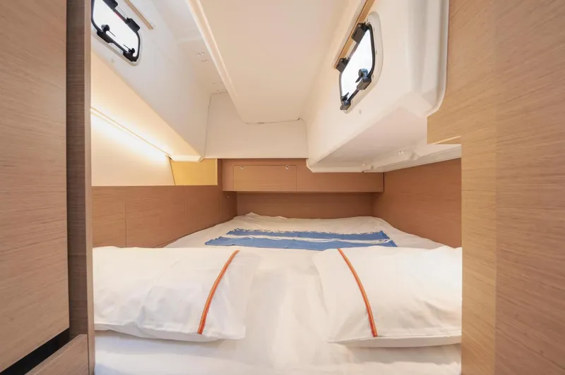  Yacht Photos Pics 2026 Jeanneau Sun Odyssey 350 cabin interior with cozy bed and natural wood finish.