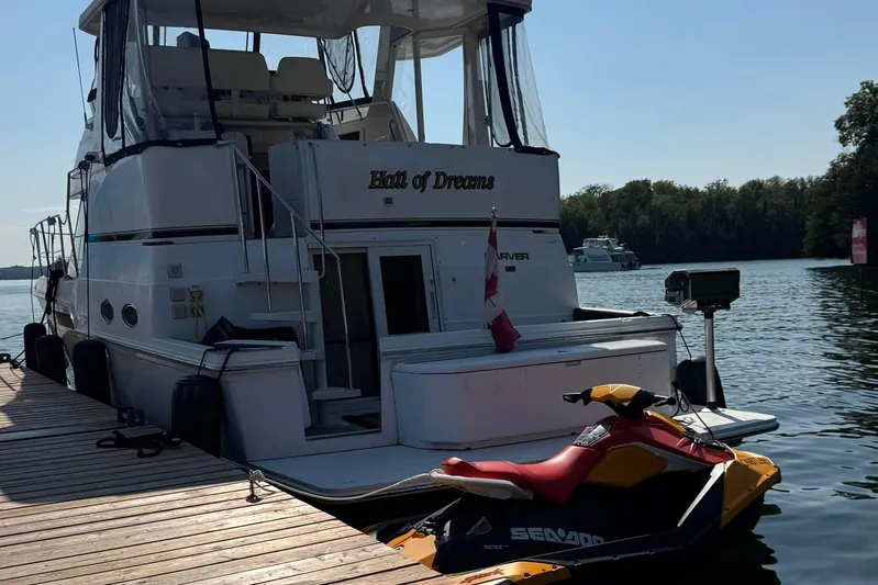  Yacht Photos Pics Carver 404 Cockpit Motor Yacht 2000 docked with Sea-Doo jet ski, scenic water view.