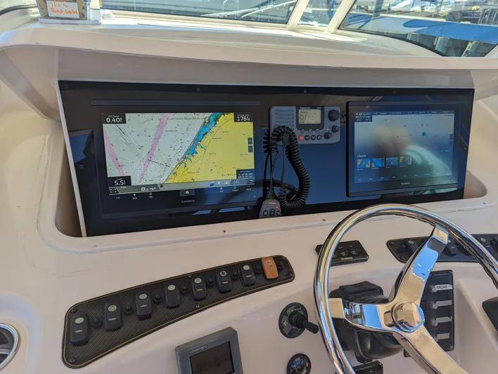 Yacht Photos Pics Control panel of 2012 Grady-White Canyon 366 boat with navigation screens and steering wheel.