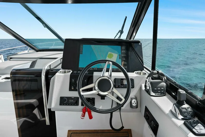 Over The Top Yacht Photos Pics Helm of 2021 Regal 36 boat with navigation system, steering wheel, and ocean view.