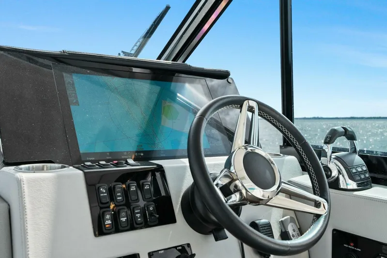 Over The Top Yacht Photos Pics 2021 Regal 36 boat helm with steering wheel and navigation screen.