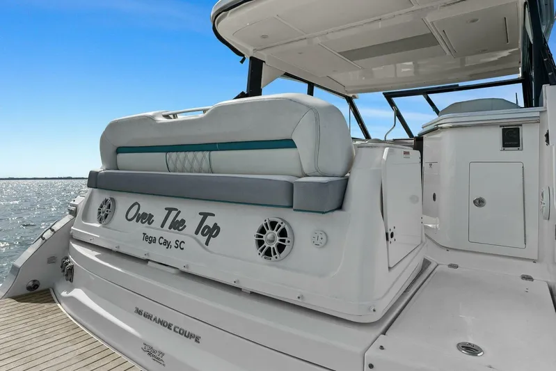 Over The Top Yacht Photos Pics 2021 Regal 36 boat with seating, "Over The Top" text, docked by water.