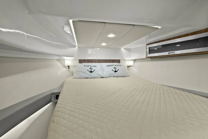 Over The Top Yacht Photos Pics 2021 Regal 36 cabin interior with cozy bed and nautical-themed pillows.