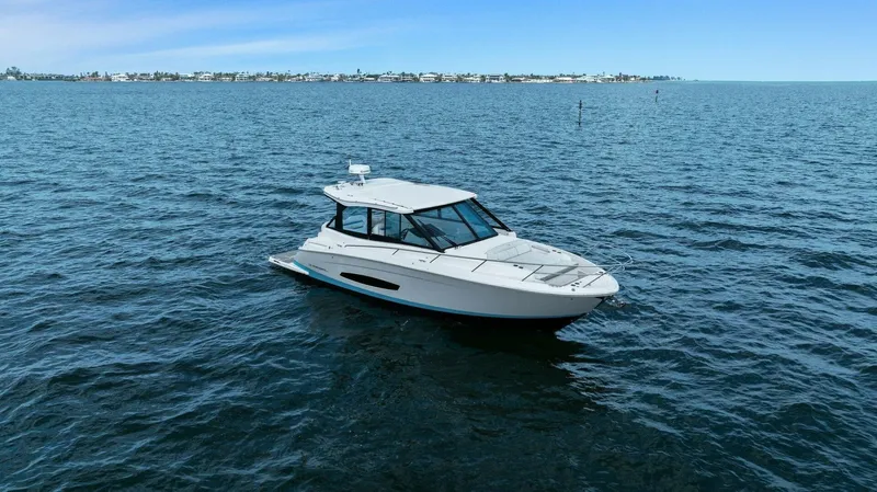 Over The Top Yacht Photos Pics 2021 Regal 36 boat cruising on open water under clear blue skies.