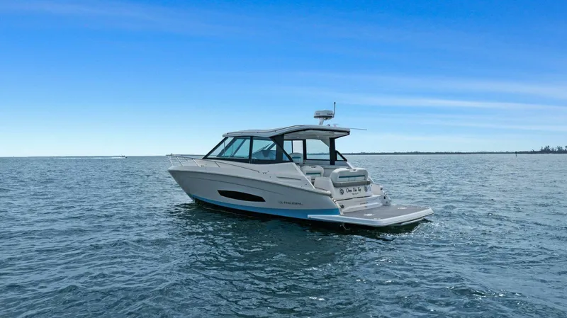Over The Top Yacht Photos Pics 2021 Regal 36 boat cruising on open water under clear blue sky.