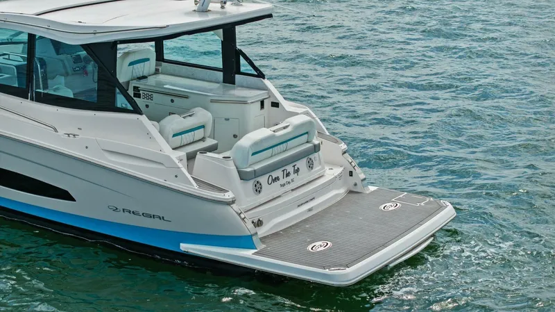 Over The Top Yacht Photos Pics 2021 Regal 36 boat on water, rear view with swim platform and seating.