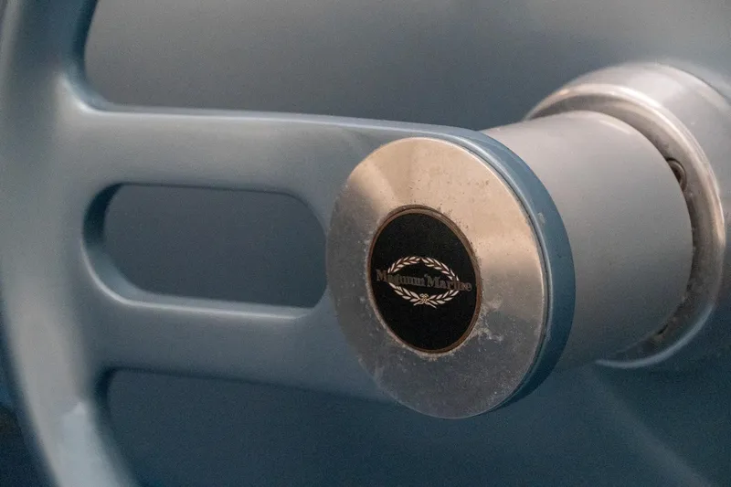  Yacht Photos Pics Close-up of a 1997 Magnum 56 steering wheel with logo detail.