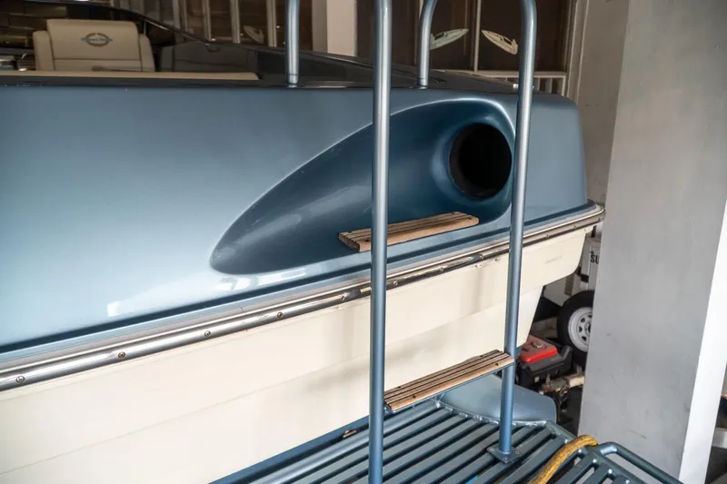  Yacht Photos Pics 1997 Magnum 56 boat stern with ladder and blue detailing in a garage.