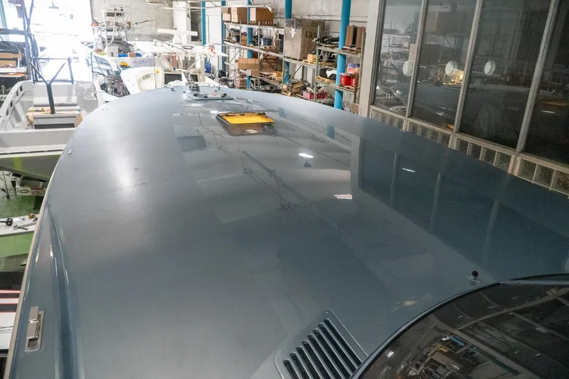  Yacht Photos Pics 1997 Magnum 56 yacht in a workshop, showcasing sleek design and reflective surface.