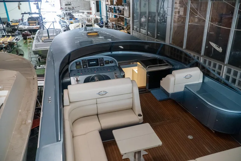  Yacht Photos Pics Luxurious 1997 Magnum 56 yacht interior with elegant seating and modern dashboard in a workshop.