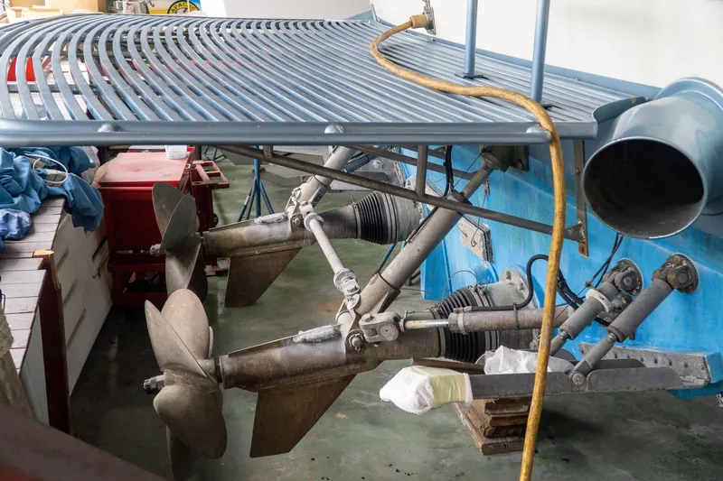  Yacht Photos Pics Boat propellers and drive system of a 1997 Magnum 56 model in a maintenance area.