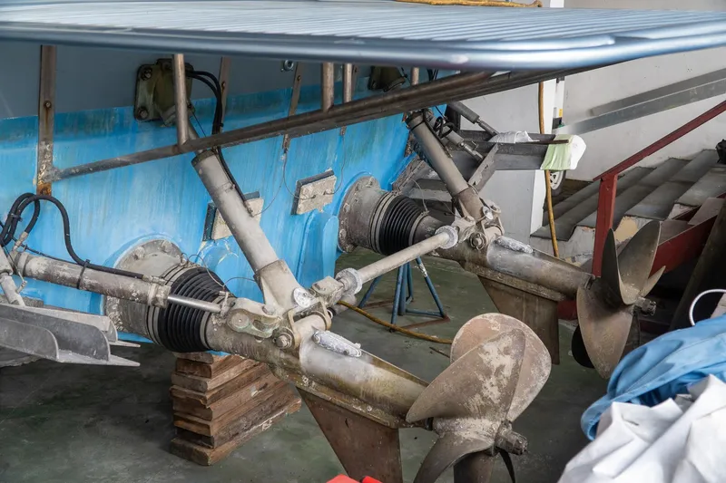  Yacht Photos Pics Close-up of a 1997 Magnum 56 boat propellers and drive system in a workshop.