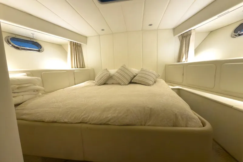  Yacht Photos Pics Luxurious cabin interior of a 1997 Magnum 56 yacht, featuring a cozy bed and elegant decor.