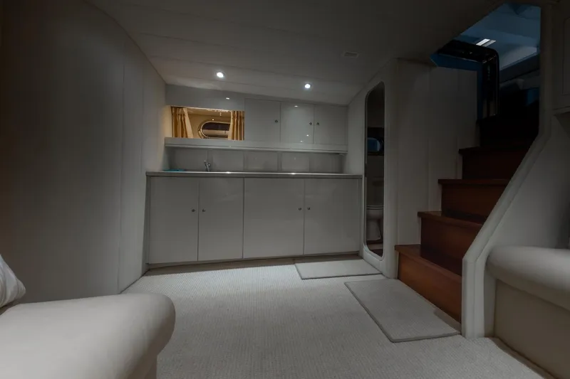  Yacht Photos Pics Interior of a 1997 Magnum 56 yacht with modern cabinetry and wooden stairs.