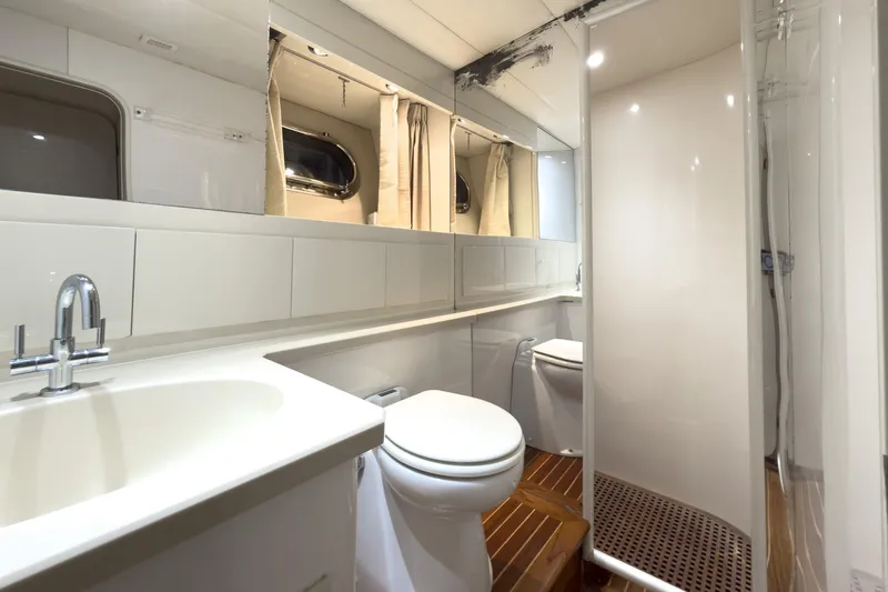  Yacht Photos Pics Luxurious bathroom in 1997 Magnum 56 yacht with modern fixtures and wooden flooring.