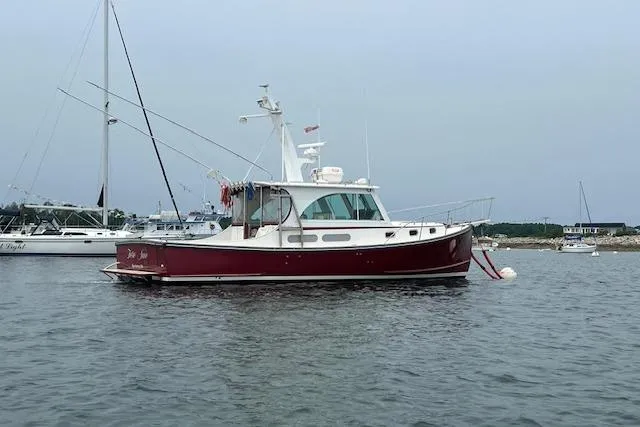 Tere Sue Yacht Photos Pics 2007 Northern Bay Hardtop Cruiser/Fishing Vessel on calm water, red hull, anchored near shore.
