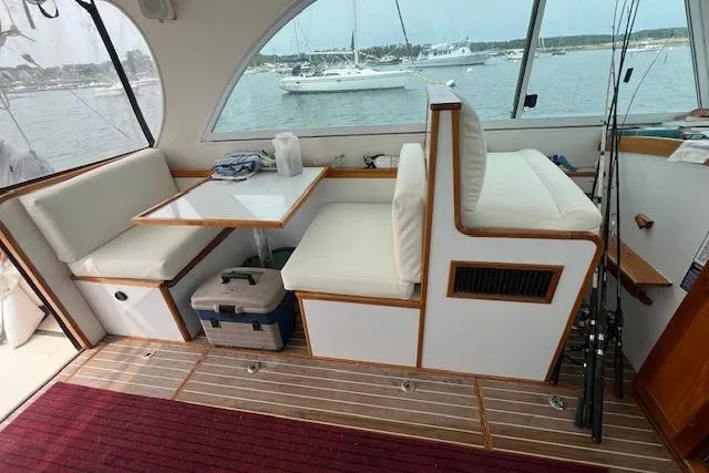 Tere Sue Yacht Photos Pics Interior of 2007 Northern Bay Hardtop Cruiser with seating, table, and fishing rods.