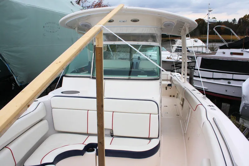  Yacht Photos Pics 2013 Pursuit ST 310 Sport boat with white seating and protective cover.