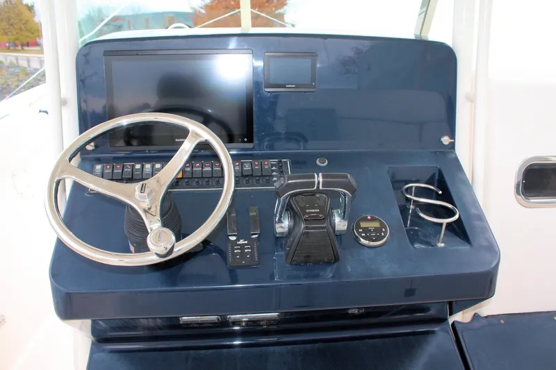  Yacht Photos Pics Control panel of 2013 Pursuit ST 310 Sport boat with steering wheel and navigation equipment.