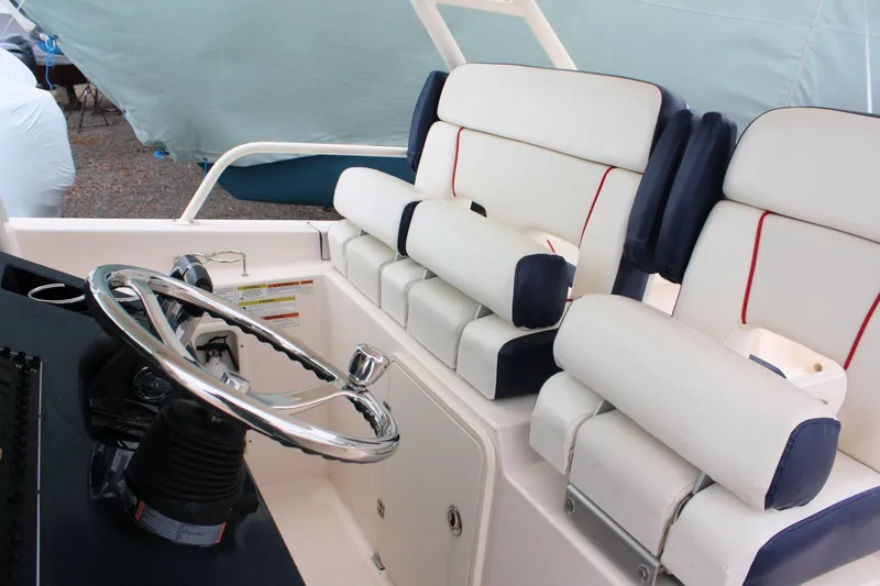  Yacht Photos Pics 2013 Pursuit ST 310 Sport boat interior with steering wheel and cushioned seating.