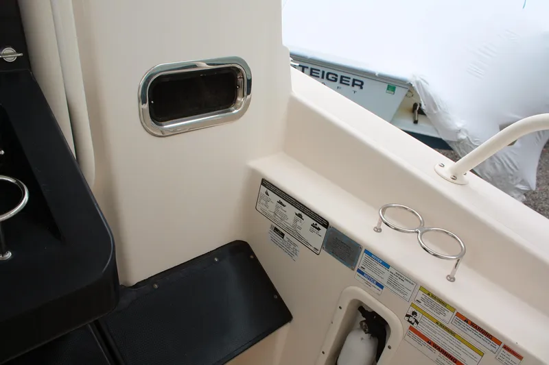  Yacht Photos Pics Interior view of a 2013 Pursuit ST 310 Sport boat, featuring safety labels and cup holders.