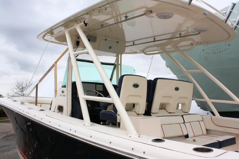  Yacht Photos Pics 2013 Pursuit ST 310 Sport boat with seating and canopy, docked under cloudy skies.
