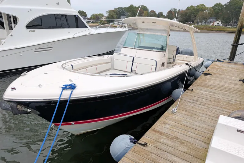  Yacht Photos Pics 2013 Pursuit ST 310 Sport boat docked at a marina, side view.