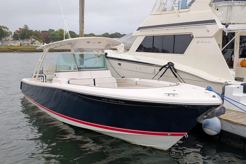  Yacht Photos Pics 2013 Pursuit ST 310 Sport boat docked in a marina, featuring sleek design and spacious deck.