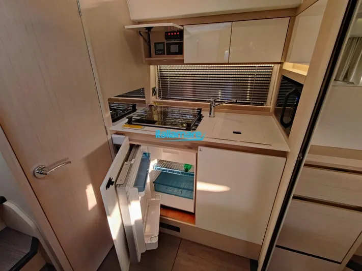  Yacht Photos Pics Compact kitchen area in a 2020 Jeanneau Leader 36 yacht, featuring modern appliances and storage.