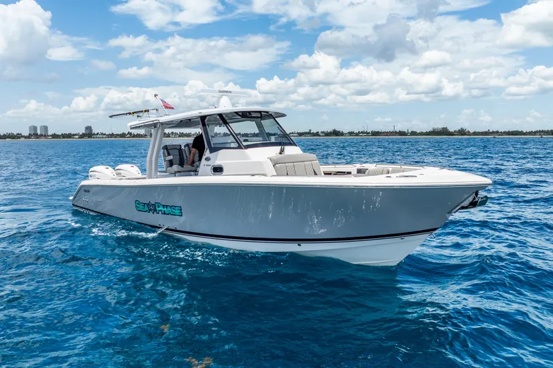 Sea Phase Yacht Photos Pics 2024 Pursuit S 358 Sport boat cruising on clear blue ocean waters.