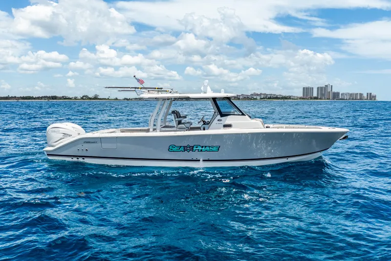 Sea Phase Yacht Photos Pics 2024 Pursuit S 358 Sport boat cruising on blue ocean under clear sky.