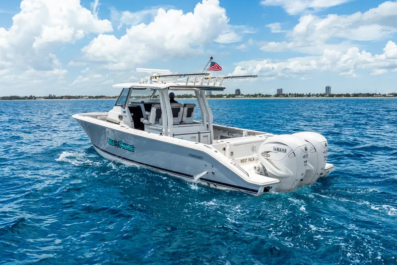 Sea Phase Yacht Photos Pics 2024 Pursuit S 358 Sport boat cruising on blue ocean under a clear sky.