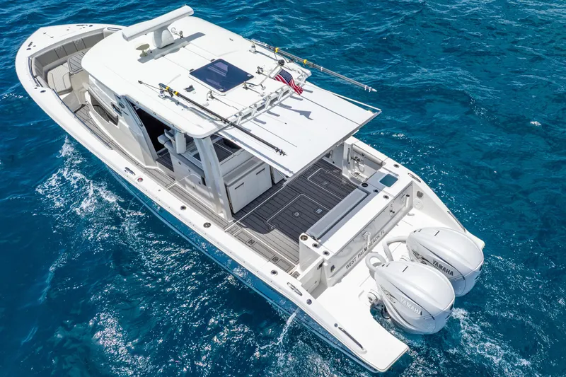 Sea Phase Yacht Photos Pics 2024 Pursuit S 358 Sport boat cruising on clear blue ocean waters.