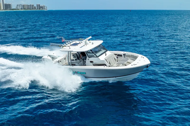 Sea Phase Yacht Photos Pics 2024 Pursuit S 358 Sport boat cruising on open blue ocean waters.
