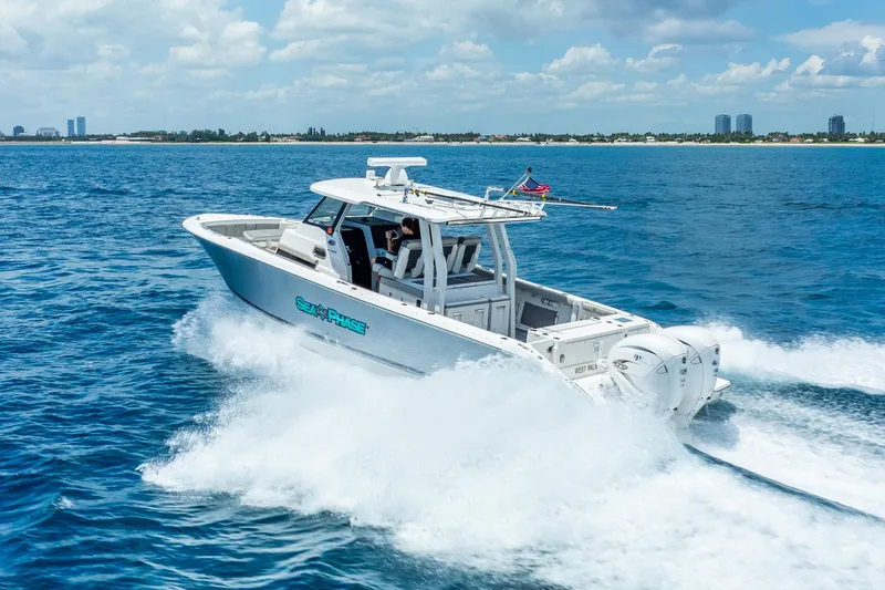 Sea Phase Yacht Photos Pics 2024 Pursuit S 358 Sport boat cruising on open water under a clear sky.