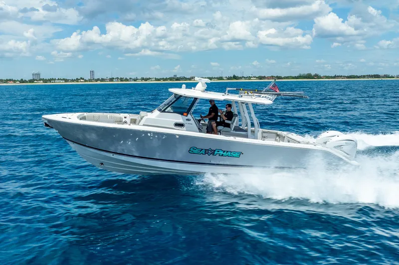Sea Phase Yacht Photos Pics 2024 Pursuit S 358 Sport boat cruising on open blue water under a cloudy sky.
